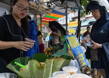 Người dân đội mưa đi sắm lễ trong ngày Tết Đoan Ngọ ở Hà Nội